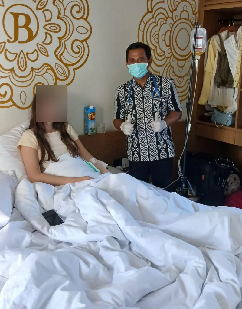 Doctor attending a guest with an IV drip in a hotel suite in Bali