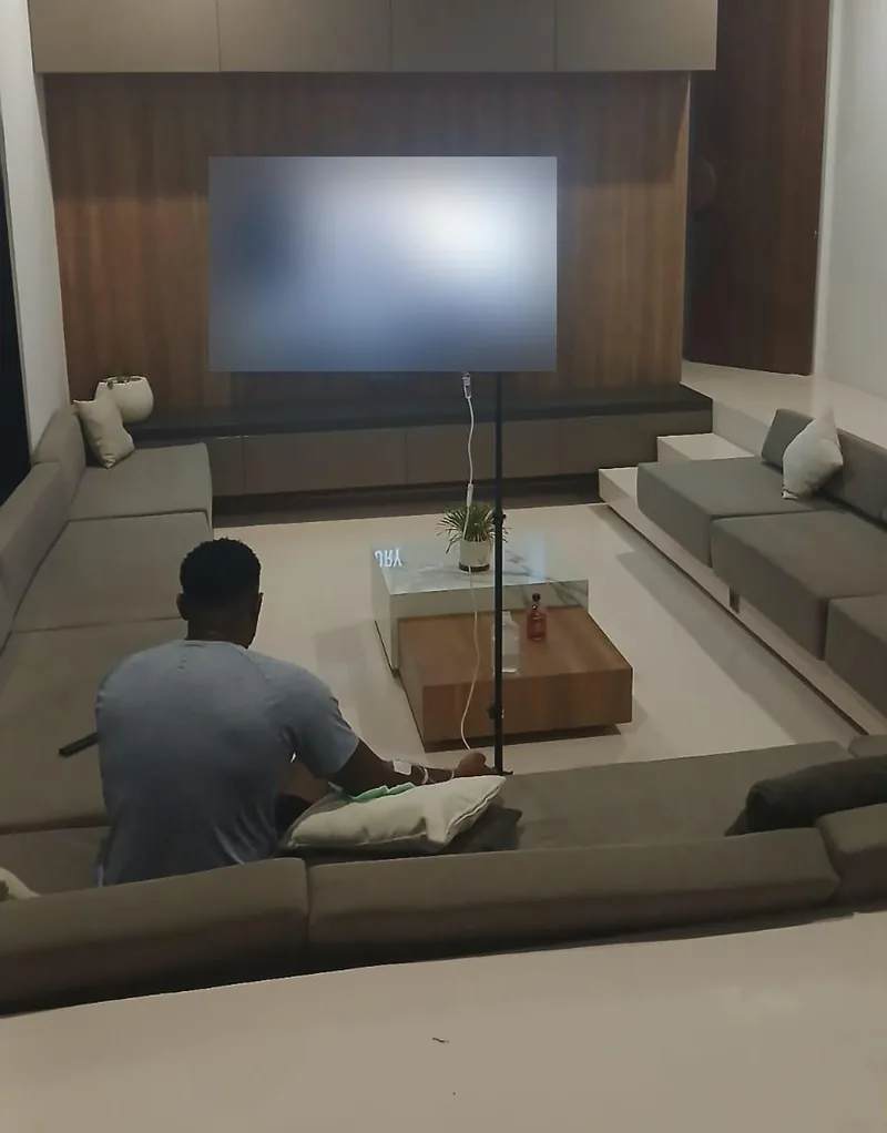 Guest recovering on a sofa in a Bali villa lounge with an IV stand nearby